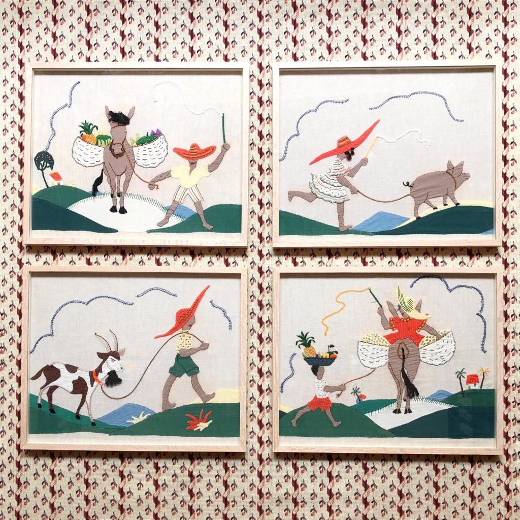Four wooden framed embroidered cotton folk art pictures